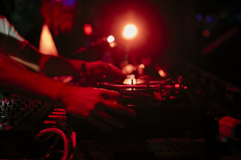close view hands disc jockey mixing vinyl records during performs music festiva - Prism.fm